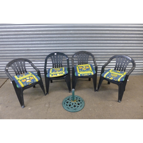 5215 - Four plastic garden chairs with cushions and a parasol base