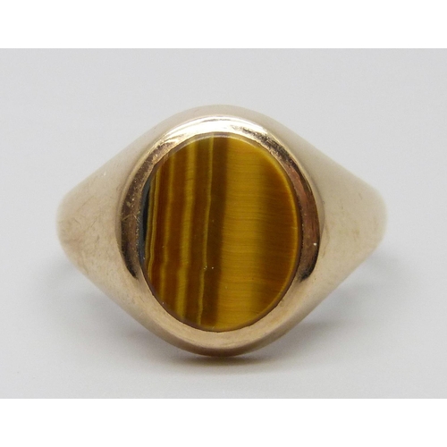 7004 - A 9ct gold ring set with tigers eye, 4.6g, S/T