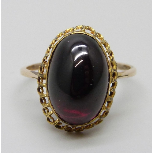 7022 - An antique yellow metal ring set with a cabochon garnet, 3.1g, M