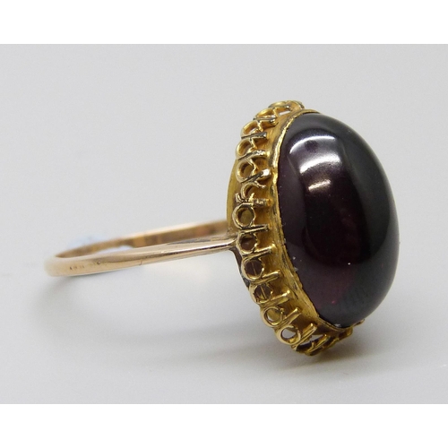 7022 - An antique yellow metal ring set with a cabochon garnet, 3.1g, M