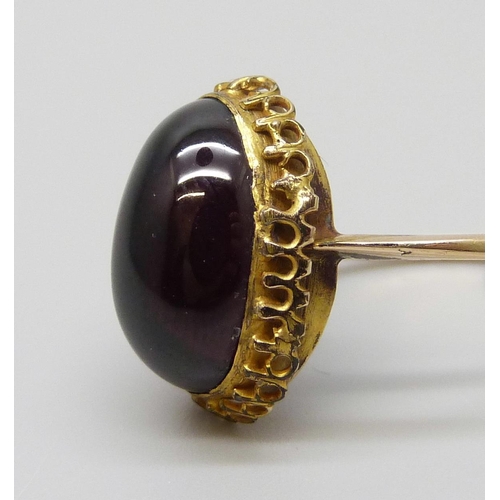 7022 - An antique yellow metal ring set with a cabochon garnet, 3.1g, M