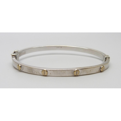 7028 - A 9ct gold bangle with screw detail, 6.9g, 51mm x 60mm