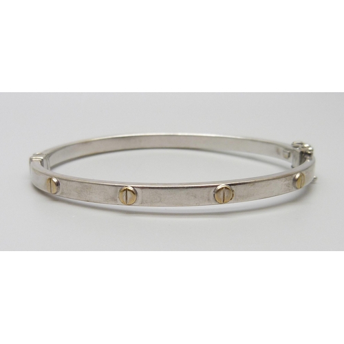 7028 - A 9ct gold bangle with screw detail, 6.9g, 51mm x 60mm