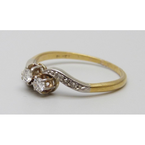 7066 - An 18ct gold, platinum set two stone diamond crossover ring, 2.5g, R