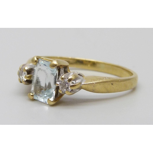 7074 - An 18ct gold two stone diamond and single aquamarine set ring, 3.8g, L