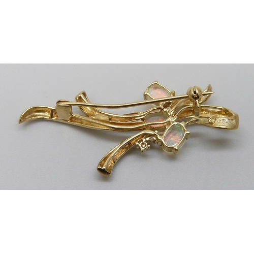 7105 - A 9ct gold brooch set with three synthetic opals and a diamond, 3.7g, 4.5cm