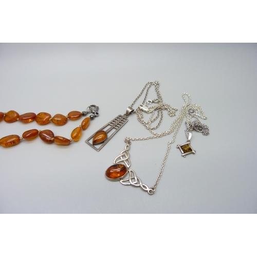 7130 - Three silver and amber pendants on chains, together with other amber