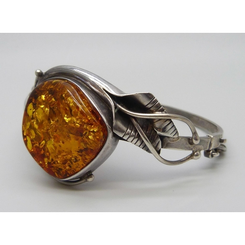 7135 - An Art Nouveau style silver and amber bangle, 31g