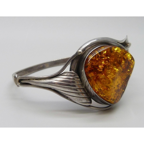 7135 - An Art Nouveau style silver and amber bangle, 31g