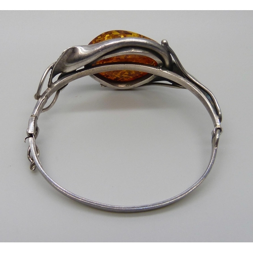 7135 - An Art Nouveau style silver and amber bangle, 31g