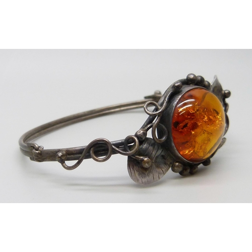 7138 - An Art Nouveau style silver and amber bangle, 14g