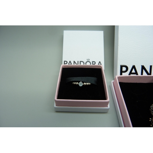 7148 - A Pandora necklace with six charms, and a Pandora ring, K