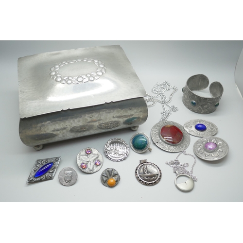 7211 - A pewter jewellery casket with a collection of pewter jewellery including Ruskin style brooches