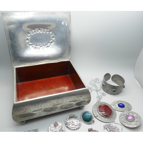 7211 - A pewter jewellery casket with a collection of pewter jewellery including Ruskin style brooches