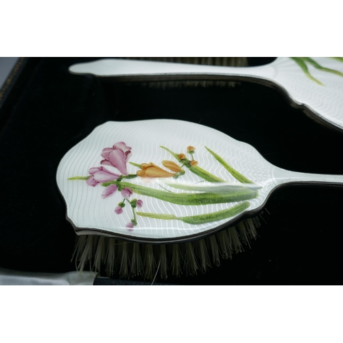 7333 - An enamelled hand mirror and brush set, in a case, (comb a/f)