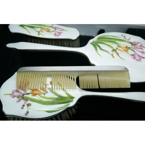 7333 - An enamelled hand mirror and brush set, in a case, (comb a/f)