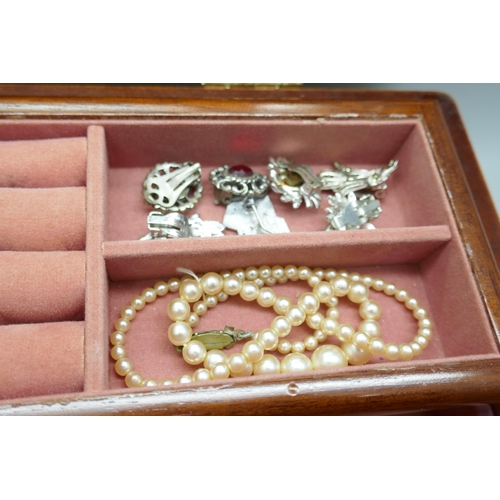 7334 - Two silver brushes, a plated card case, two compacts and costume jewellery in a jewellery box