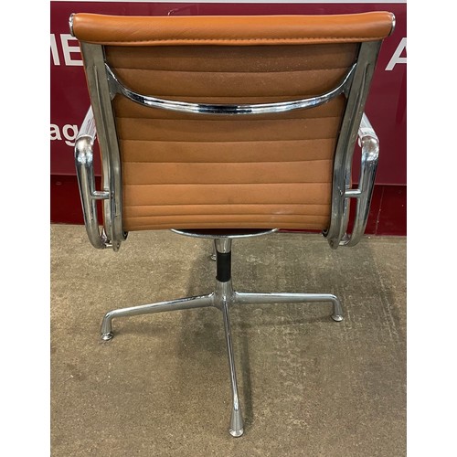 34 - An Eames style chrome and tan leather revolving desk chair