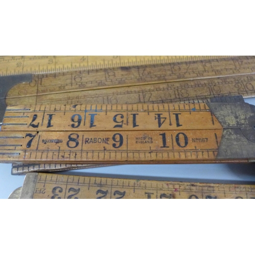 2070 - A collection of wooden rulers and two brass spirit levels