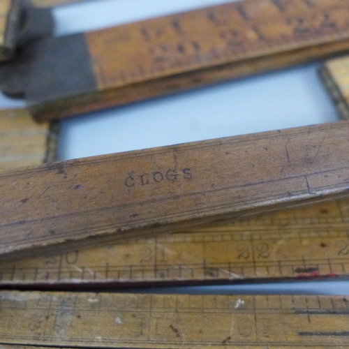 2070 - A collection of wooden rulers and two brass spirit levels