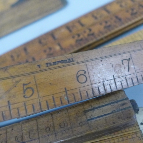 2070 - A collection of wooden rulers and two brass spirit levels