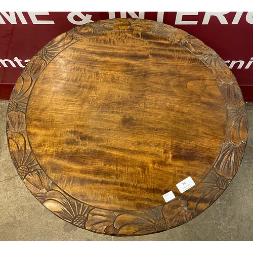 70 - An Arts and Crafts Liberty & Co. style carved beech circular occasional table