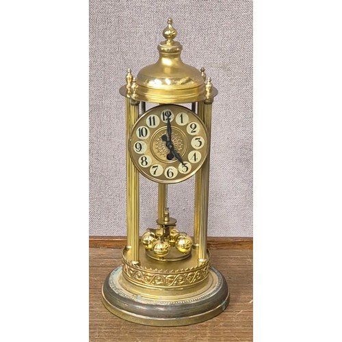 293 - An early 20th Century glass domes gilt metal torsion balance clock, with front wind, one month durat... 