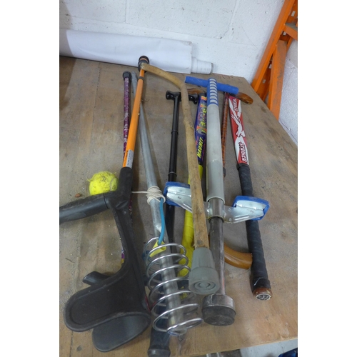 5197 - A quantity of sports equipment and walking sticks including tennis, badminton, hockey, a pogo stick,... 