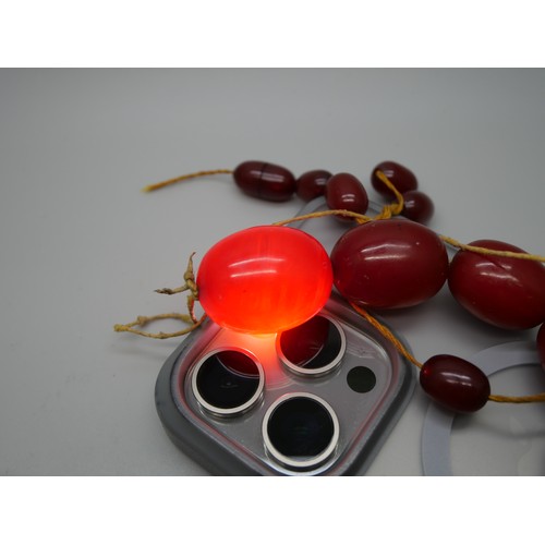 7183 - A collection of sherry amber coloured bakelite, some beads with swirl pattern, 200g