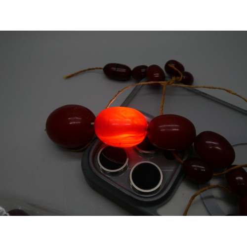 7183 - A collection of sherry amber coloured bakelite, some beads with swirl pattern, 200g