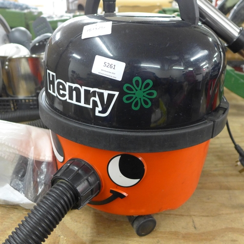 5261 - A Henry vacuum cleaner with hose pipe and a bag of attachments including a replacement bag