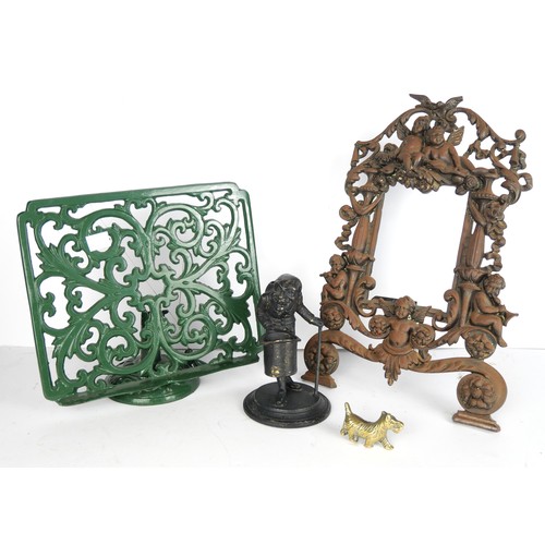 9078 - A Victorian cast iron picture frame, a cast iron music stand, a metal inkwell in the form of a man w... 