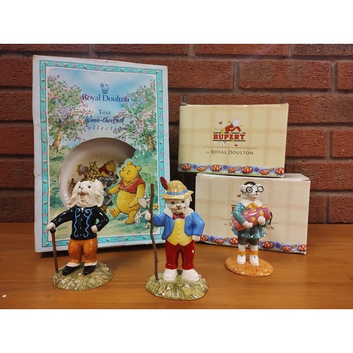 9075 - A collection of three Royal Doulton Rupert the Bear figures and Winnie the Pooh christening set