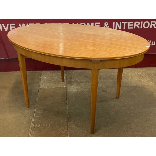 45 - A Greaves & Thomas teak oval extending dining table