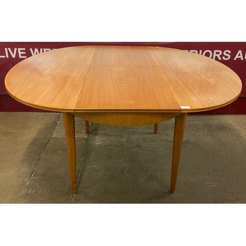 45 - A Greaves & Thomas teak oval extending dining table