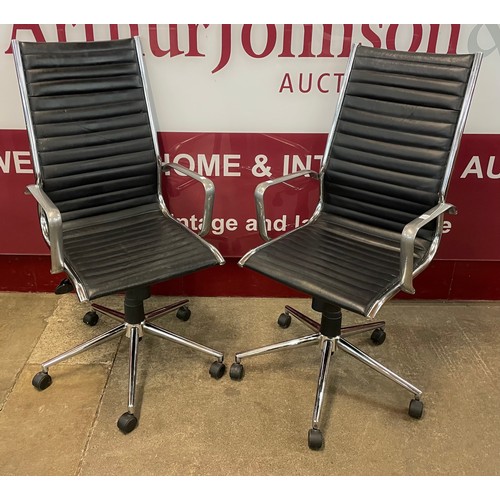 50 - A pair of Eames style chrome and black leather revolving desk chairs