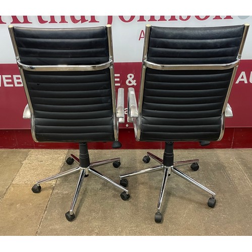 50 - A pair of Eames style chrome and black leather revolving desk chairs