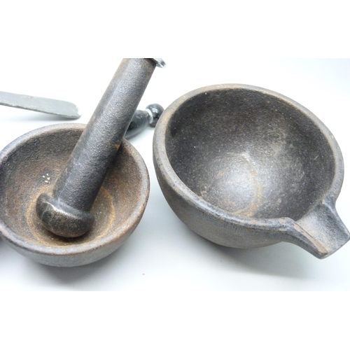 2023 - A cast iron pestle and mortar with two small sauce pans