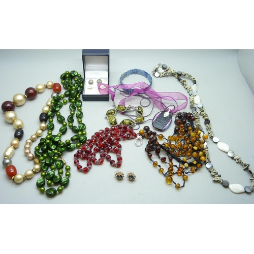 2050 - A collection of jewellery including an amber necklace, vintage red glass beads, etc.