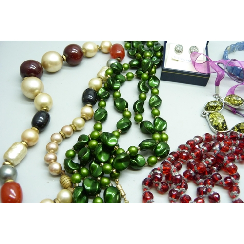 2050 - A collection of jewellery including an amber necklace, vintage red glass beads, etc.