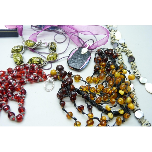 2050 - A collection of jewellery including an amber necklace, vintage red glass beads, etc.