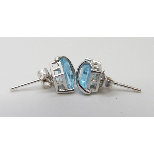 7004 - A pair of 14kt white gold blue topaz ear studs, 1.7g