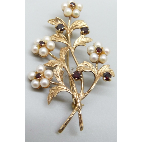 7013 - A 9ct gold, seed pearl and garnet flower spray brooch, 8.6g, 52mm