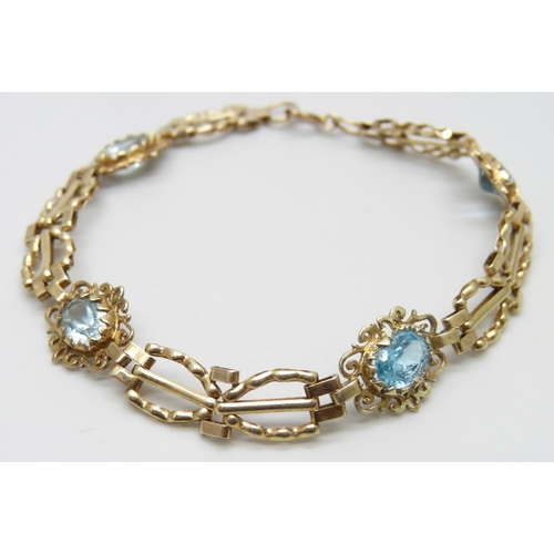 7023 - A 9ct gold and blue topaz bracelet, 5.8g, 17.5cm