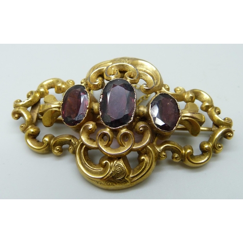 7027 - A Victorian gold plated brooch set with three amethysts, 55mm