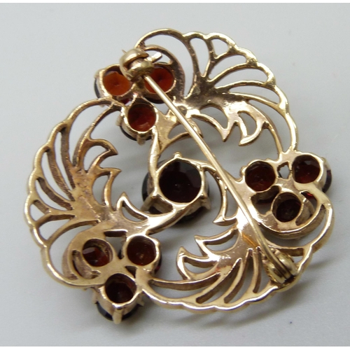 7028 - A 9ct gold and garnet brooch, 8.3g