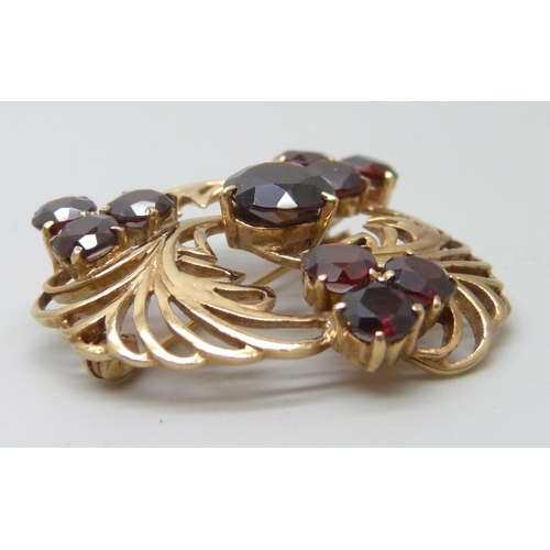 7028 - A 9ct gold and garnet brooch, 8.3g