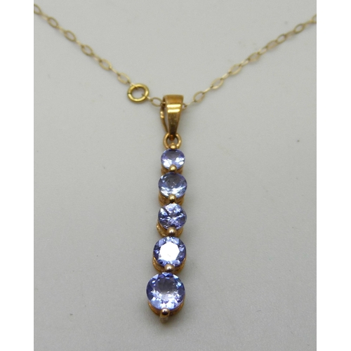 7038 - A 9ct gold five stone graduated tanzanite pendant on a fine 9ct gold chain, 1.5g