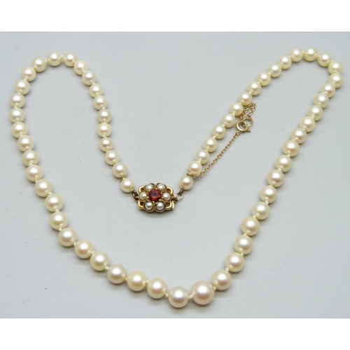 7045 - A cultured pearl necklace with 9ct gold clasp set with pearls and garnet, 43cm