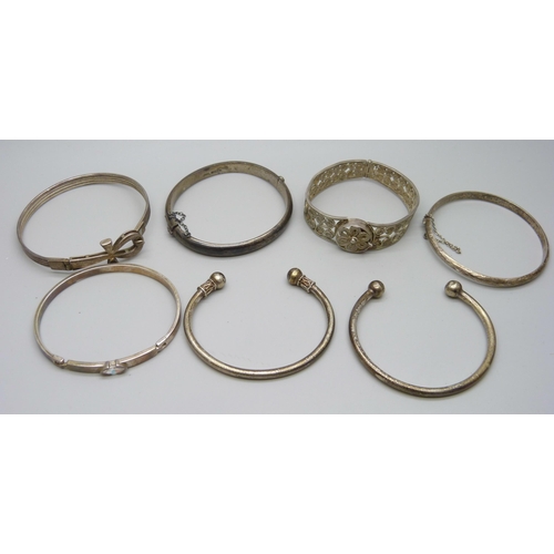 7079 - Four silver bangles, two white metal torque bangles and a filigree bangle, 86g